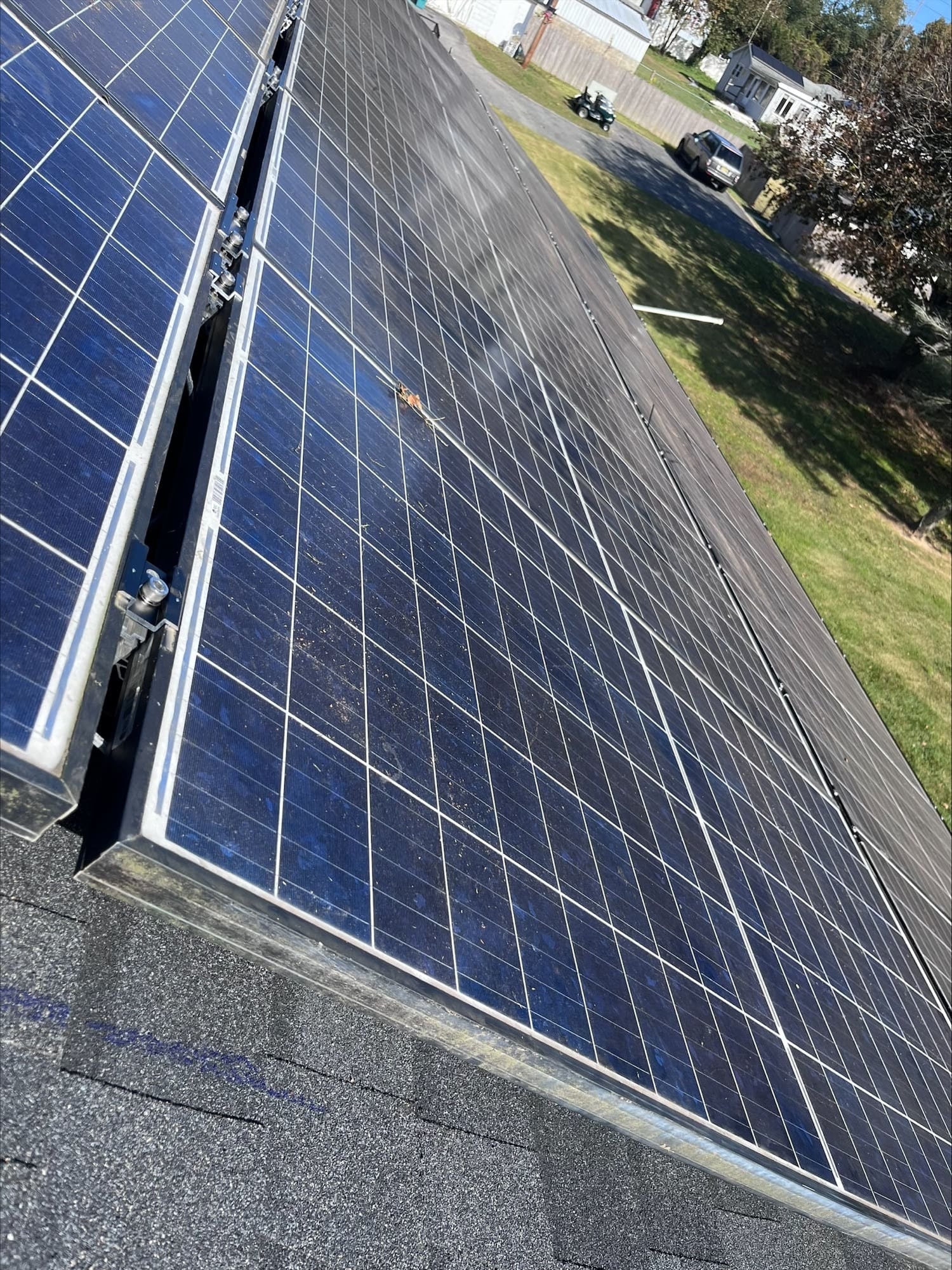 Solar panels installed on a roof with a residential area in the background.